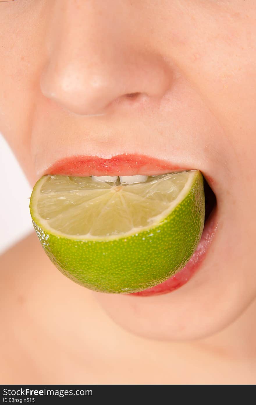 Young pretty girl biting lime