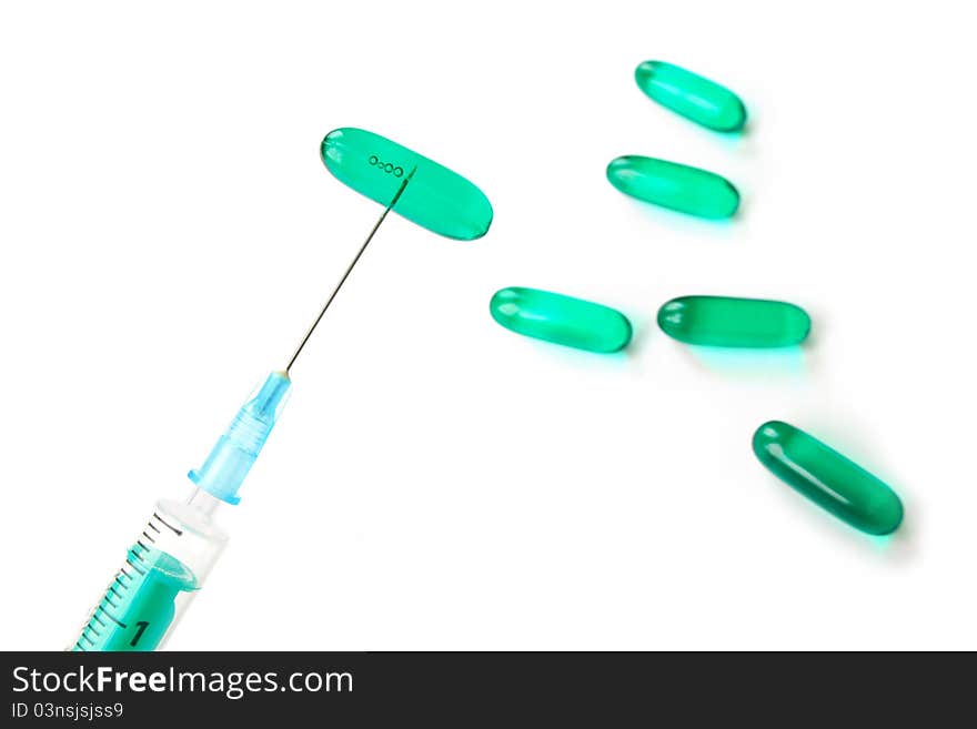 Syringe with needle and blue pills on white background. Syringe with needle and blue pills on white background.