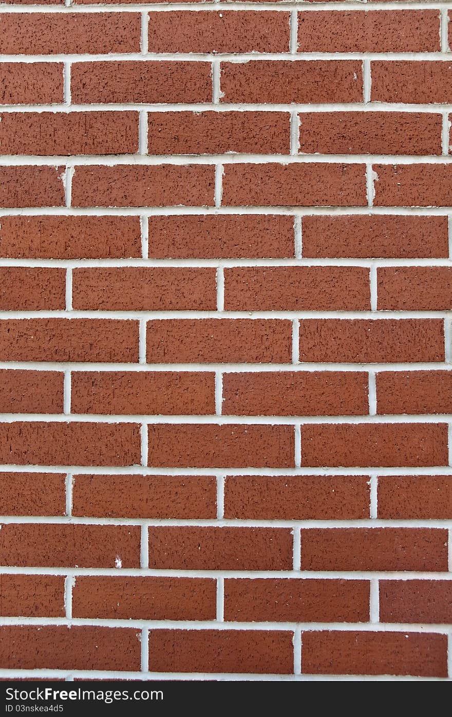 A newly built brick wall with white lines and spongy bricks. A newly built brick wall with white lines and spongy bricks