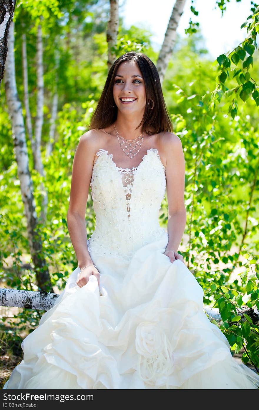 Bride with dark-brown hair posing in forest