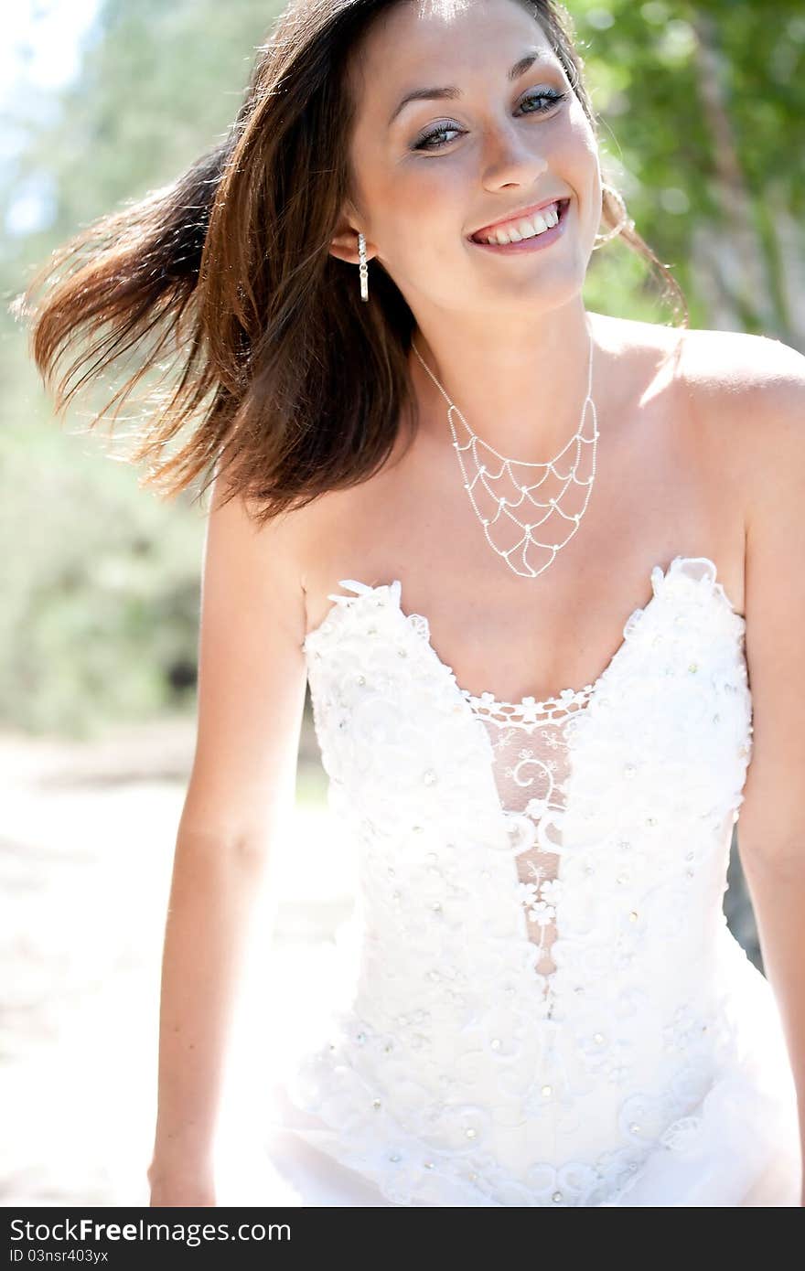 Bride with dark-brown hair posing in forest