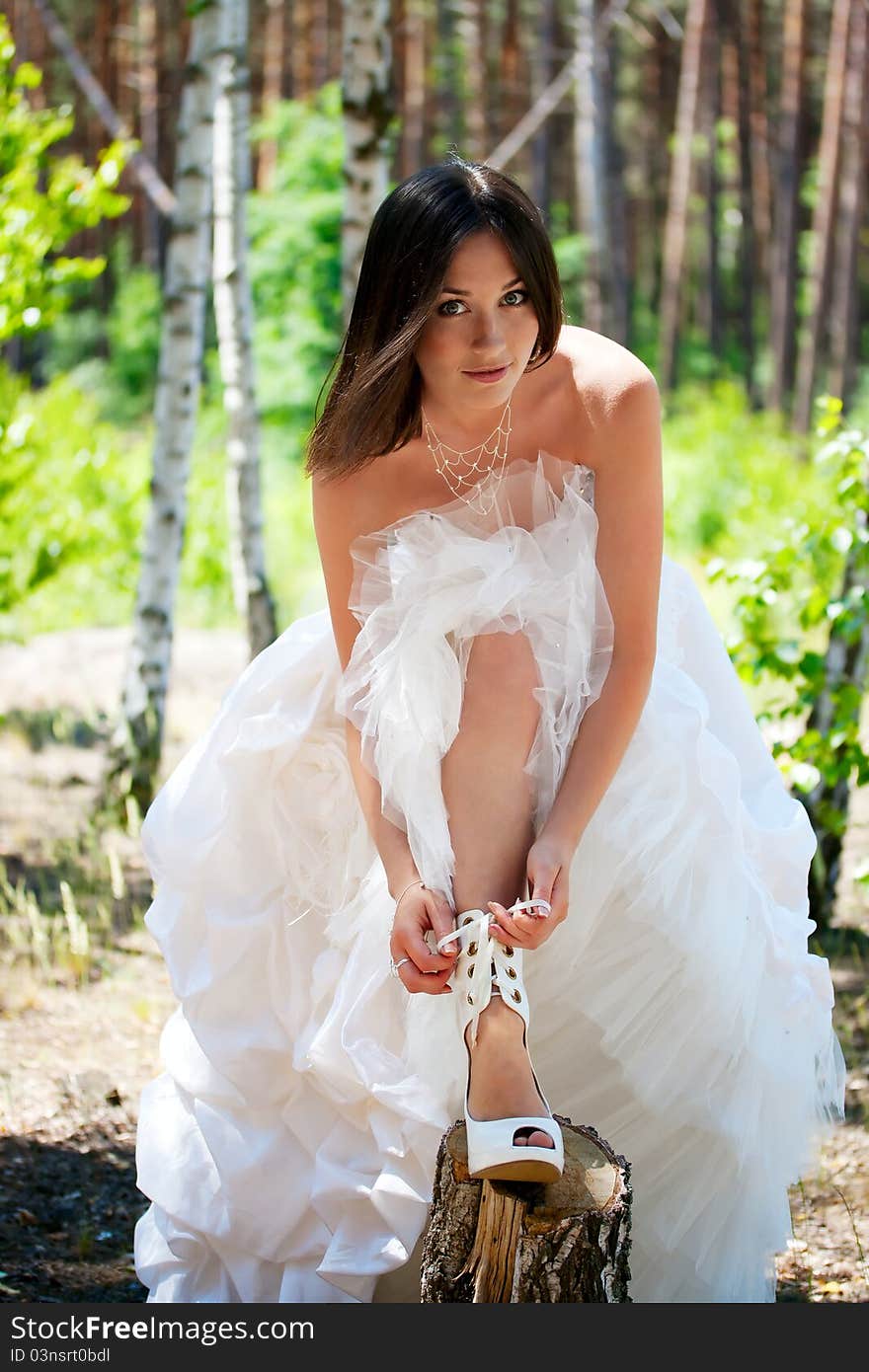 Bride with dark-brown hair posing in forest