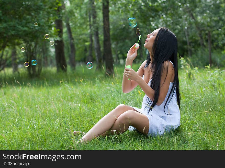 Girl inflates the bubbles in the park