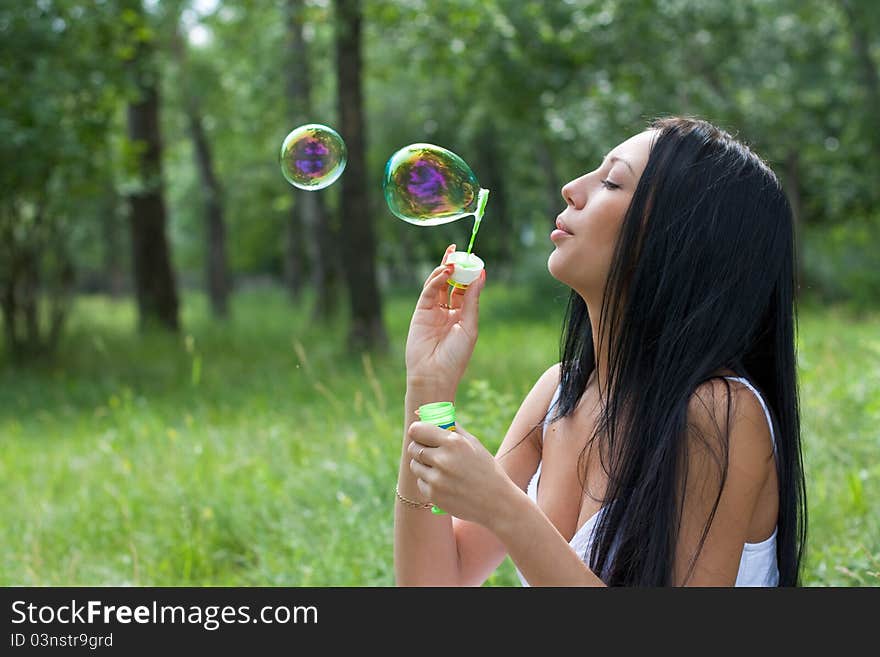 Girl inflates the bubbles in the park