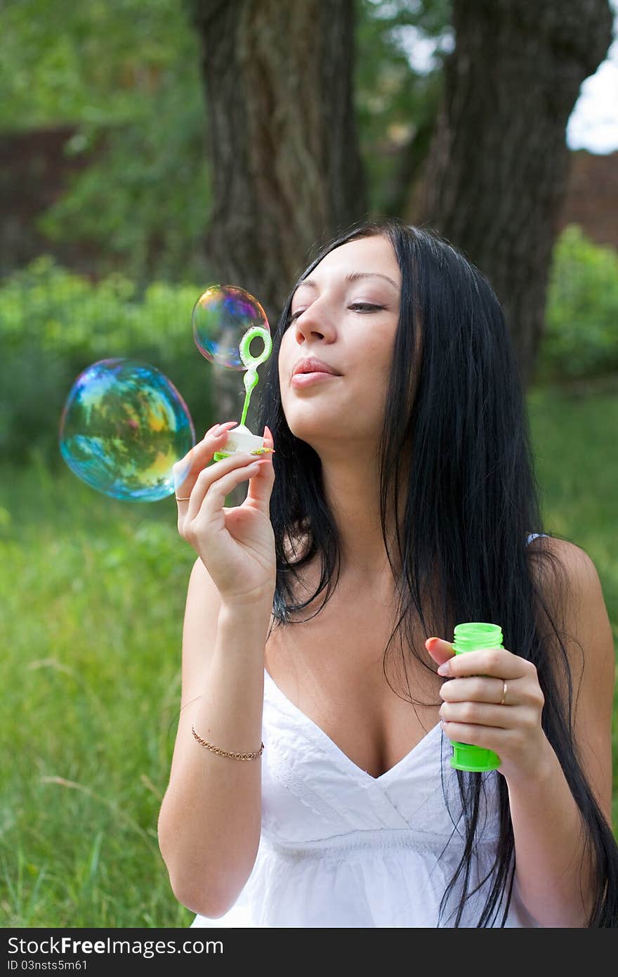 Girl inflates the bubbles in the park