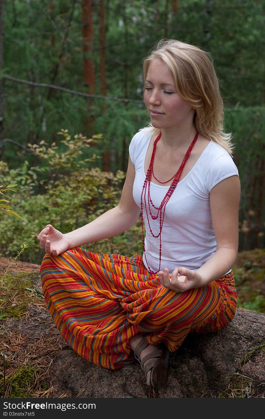 Girl practices yoga in the woods