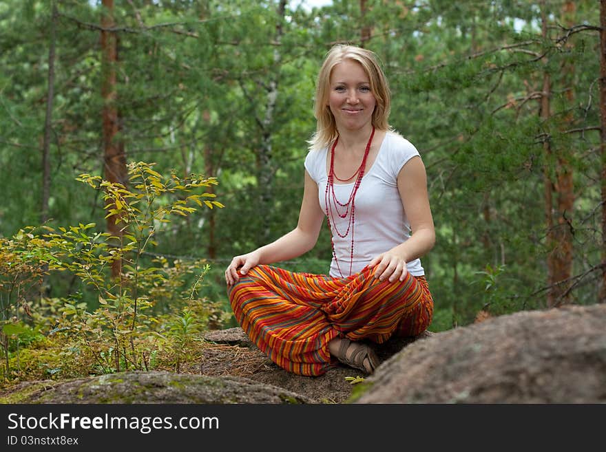 Girl practices yoga in the woods