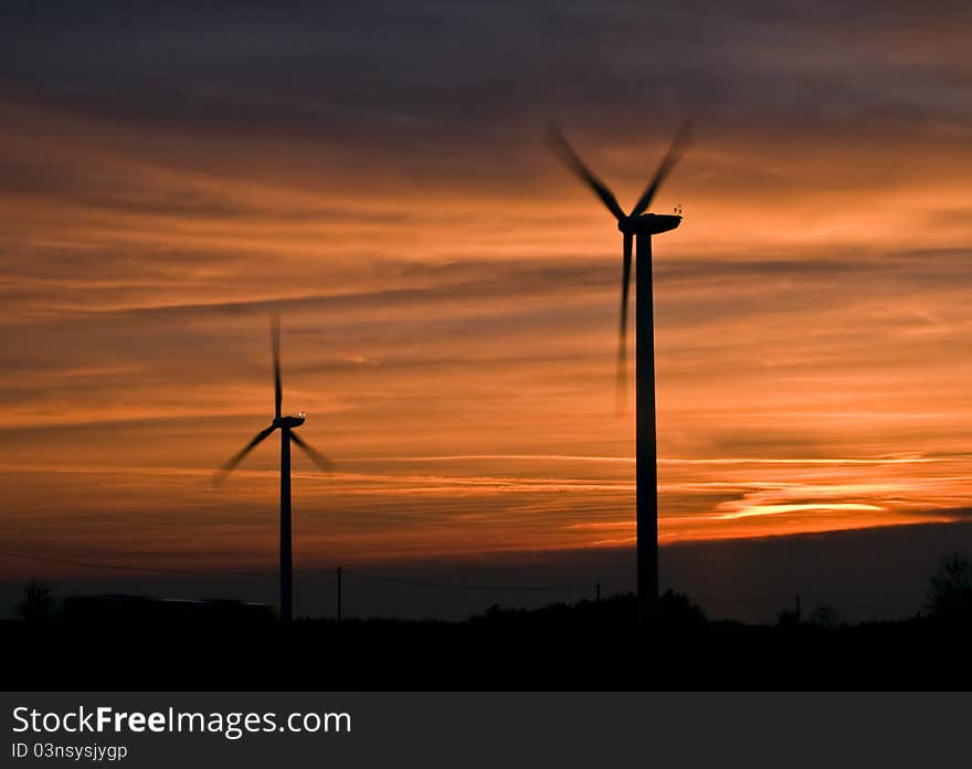 Silhouette of wind power station at sunset