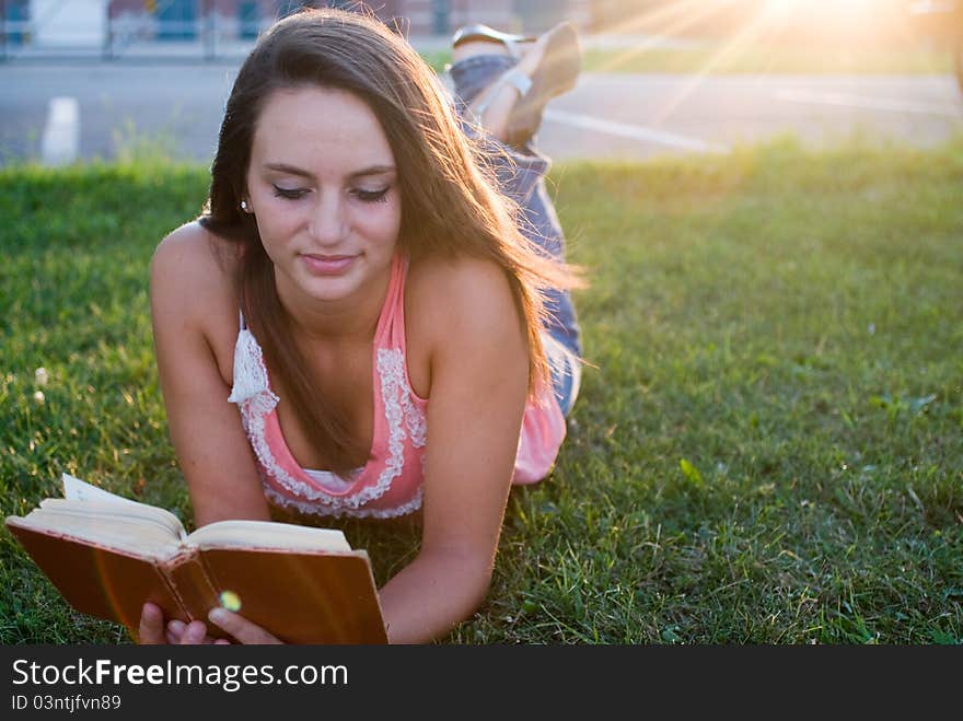 Woman laying down and reading in the twilight of the day. Woman laying down and reading in the twilight of the day.