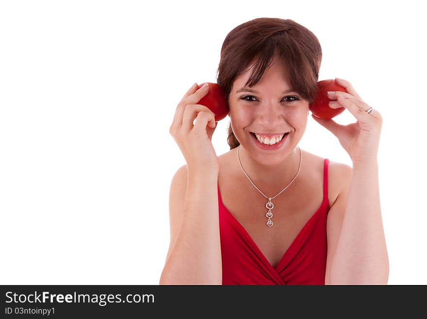 The pretty young woman holding tomatoes in the ears. The pretty young woman holding tomatoes in the ears