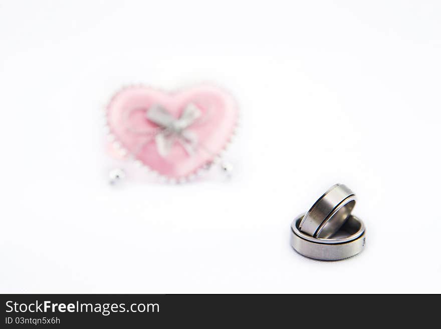 Wedding ring and pink heart isolate on white