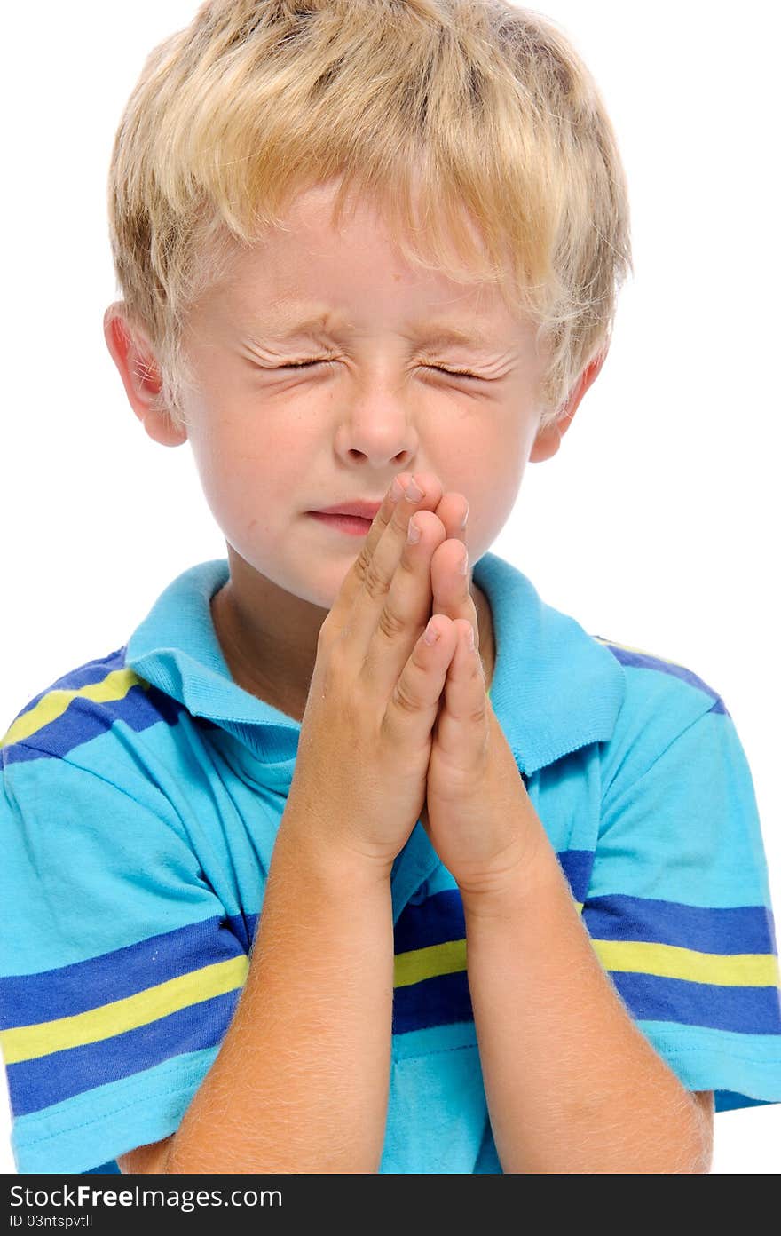 Young blonde child clasps his palms together in prayer, isolated on white. Young blonde child clasps his palms together in prayer, isolated on white