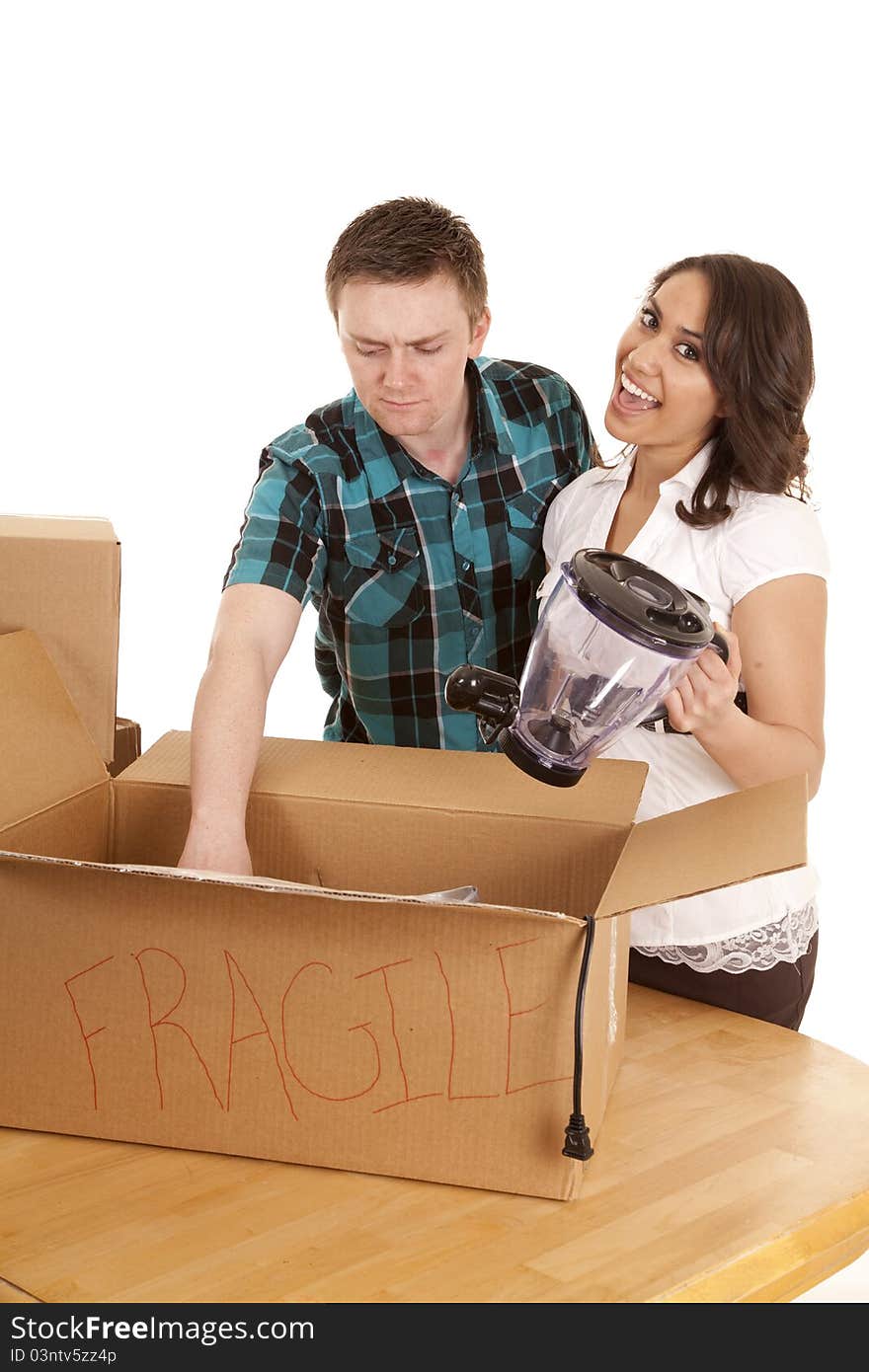 A couple unpacking dishes into their new home. A couple unpacking dishes into their new home.