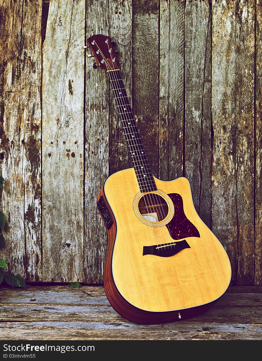 Richly toned image of a classical guitar on a grunge wood backdrop with copy space. Richly toned image of a classical guitar on a grunge wood backdrop with copy space.