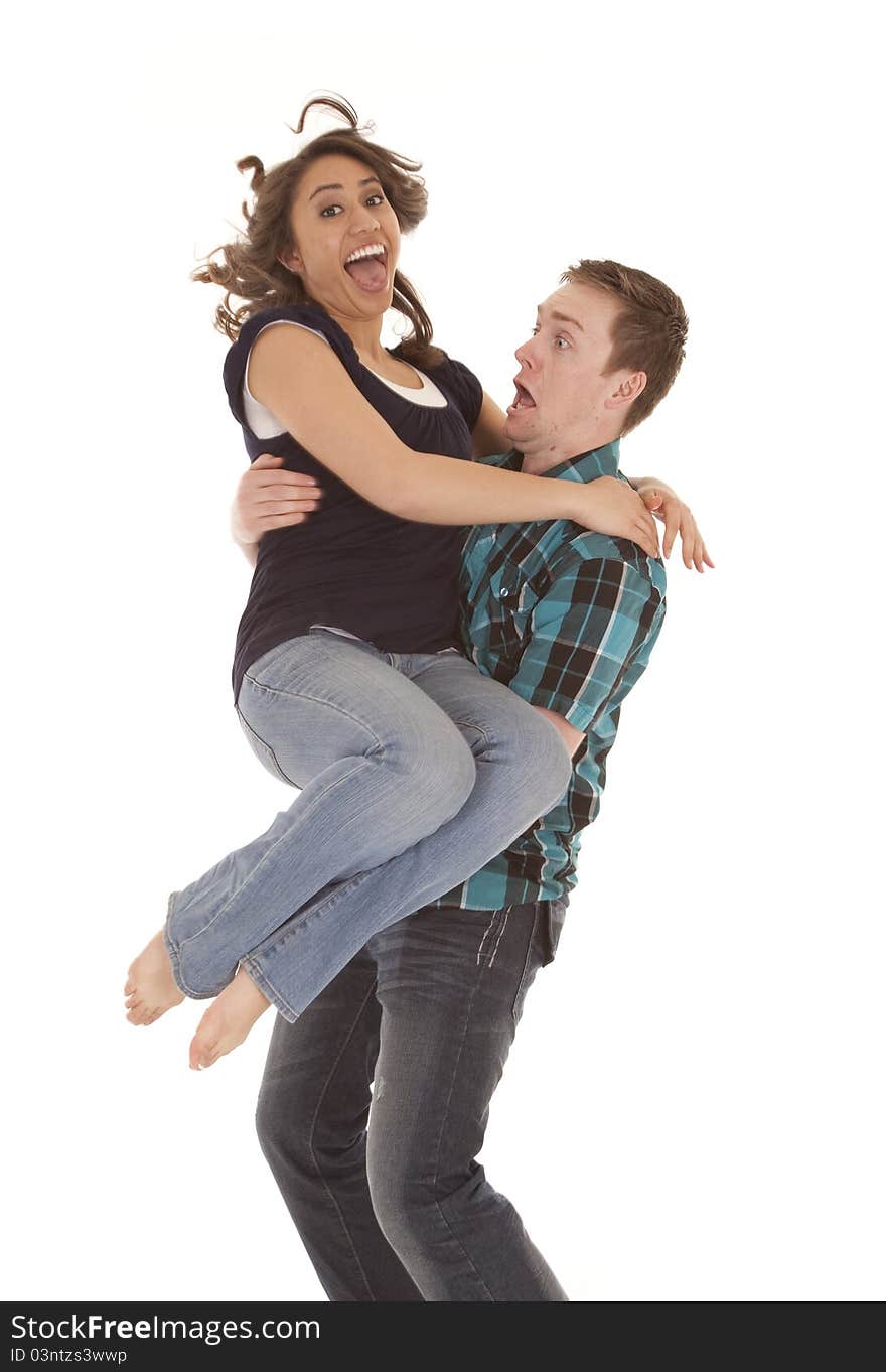 A women jumping into her mens arms with funny expressions on their faces. A women jumping into her mens arms with funny expressions on their faces.