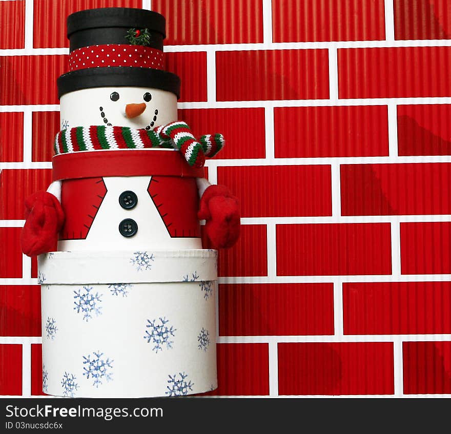 Snowman made of Gift Boxes isolated on red brick wall background