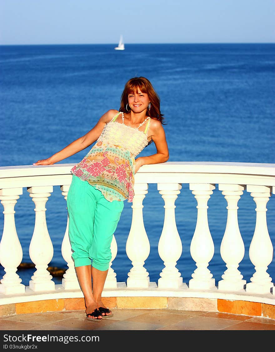 Woman on a balcony by sea (ocean)