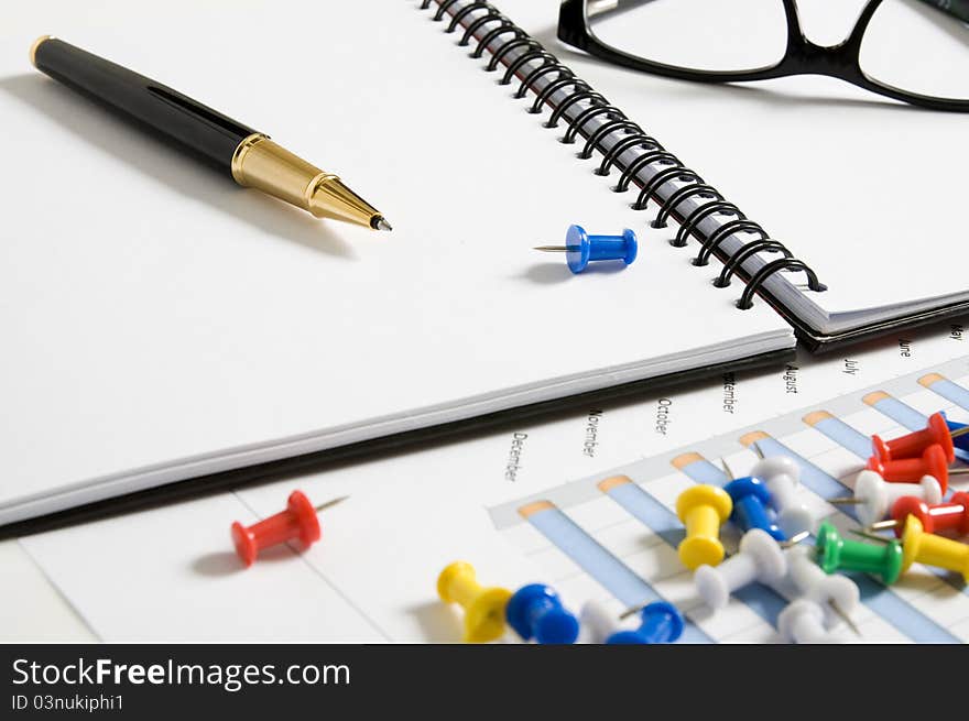 Blank agenda with pen, glasses, report paper and pins