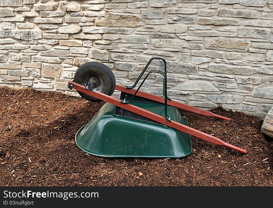 Upturned wheelbarrow against stone wall. Upturned wheelbarrow against stone wall