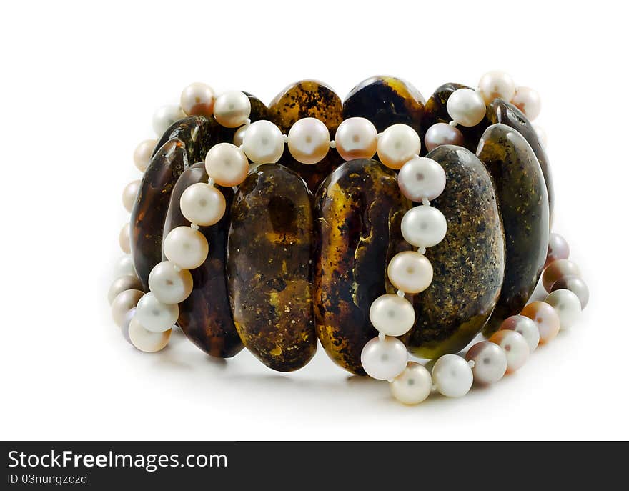 Bracelet of Baltic amber and beads necklace of pearl isolated on white background