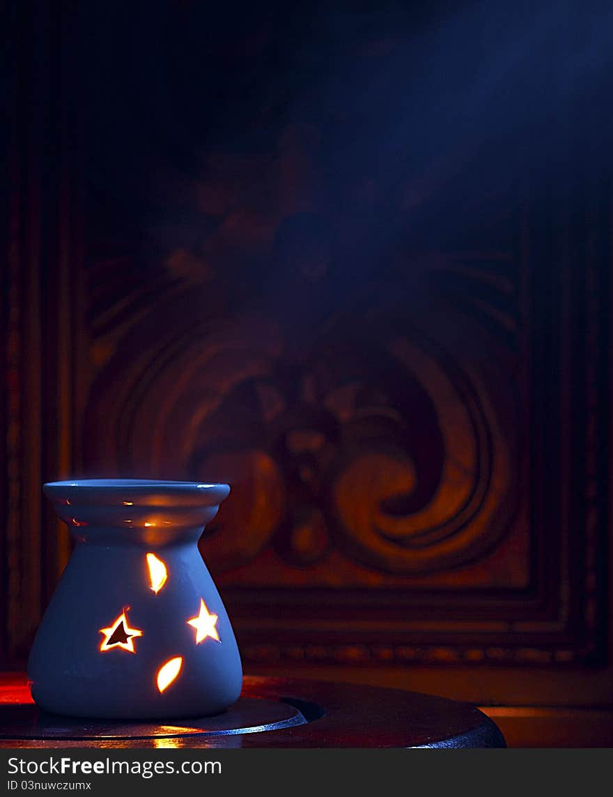 Smoking oil incense on a dark wooden background.