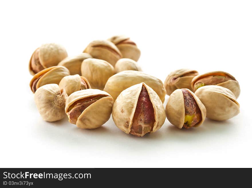 Pile of pistachios is isolated on a white background