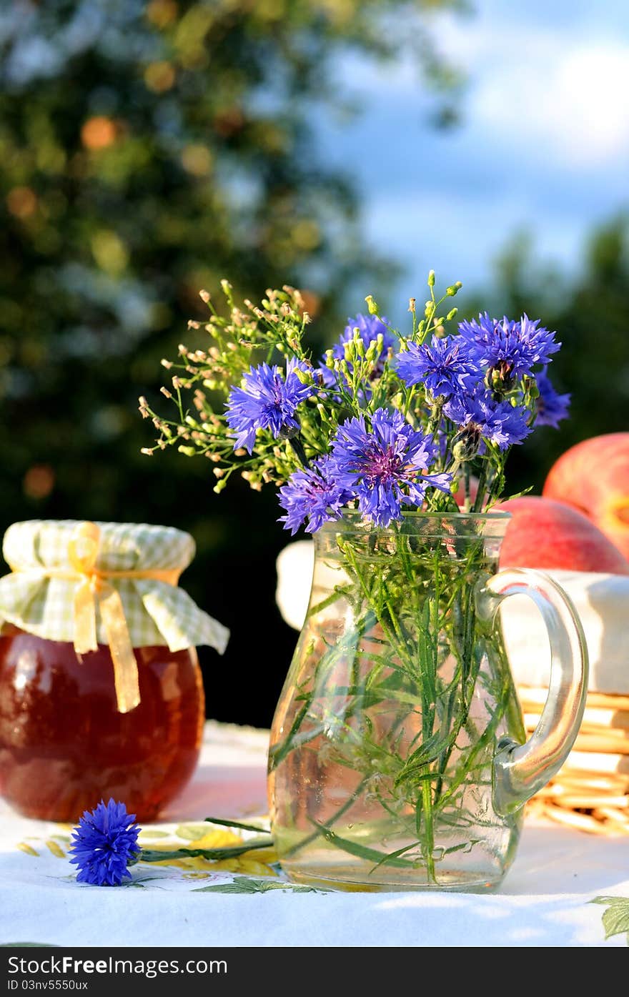 Still life with bouquet of cornflowers with garden as a background. Still life with bouquet of cornflowers with garden as a background.