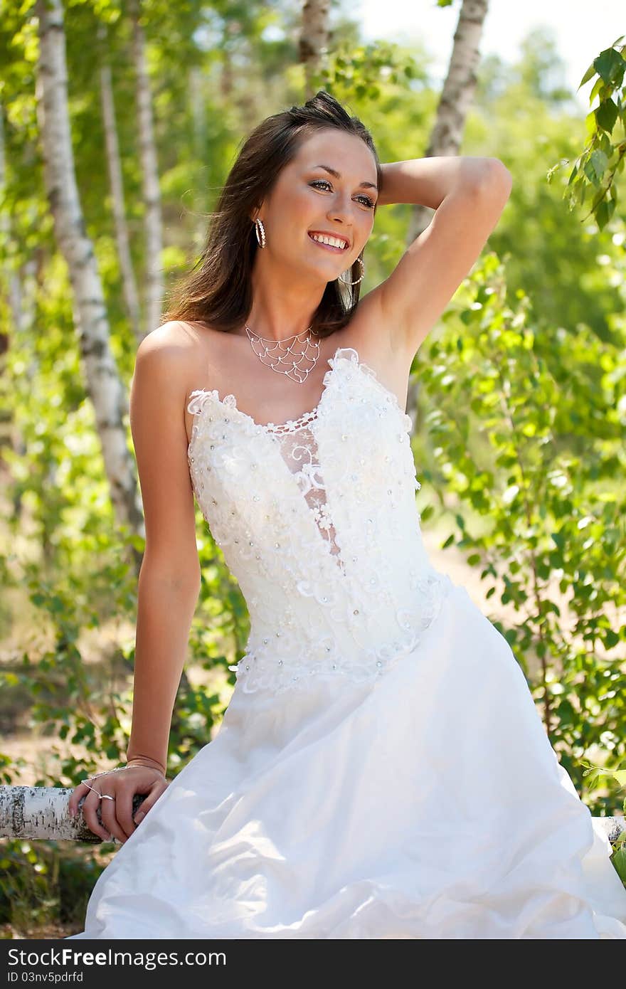 Bride with dark-brown hair posing in forest