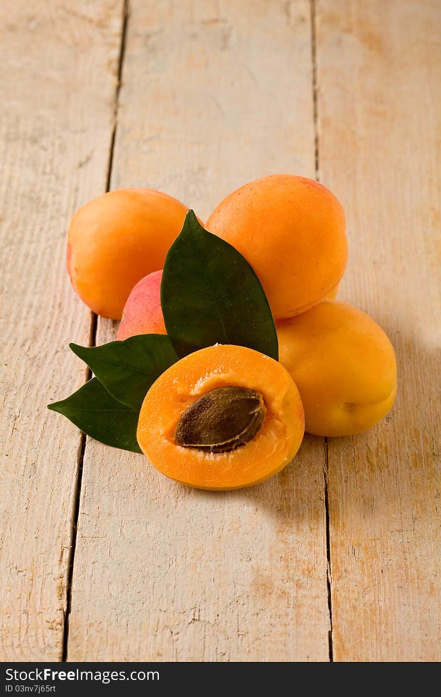 Photo of delicious tasty apricot on wooden table with leaves