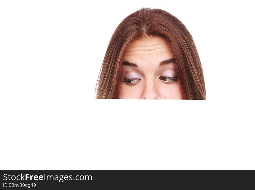 Portrait of a beautiful woman holding a blank billboard, looking out from behind it.