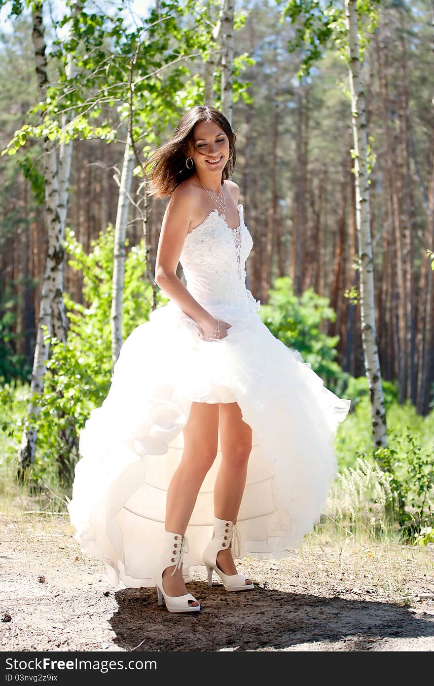 Bride with dark-brown hair posing in forest