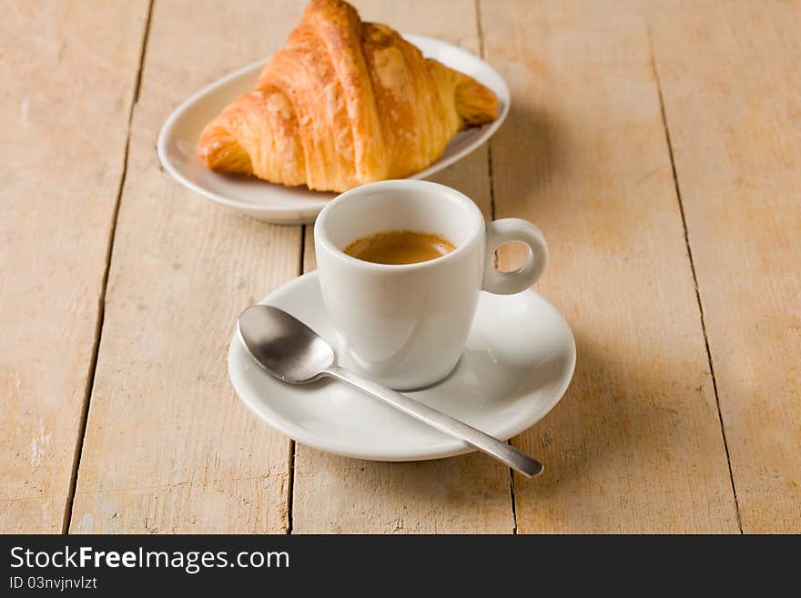 Coffee and croissants on wooden table