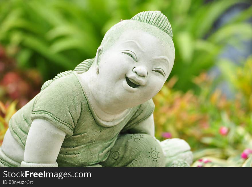 Cute smile thai child statue in the garden