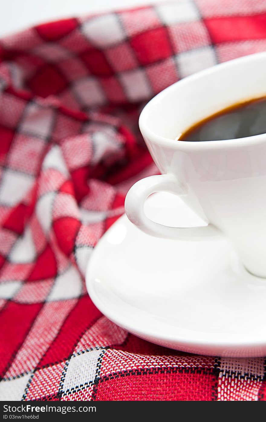 Cup of coffee is on a white saucer