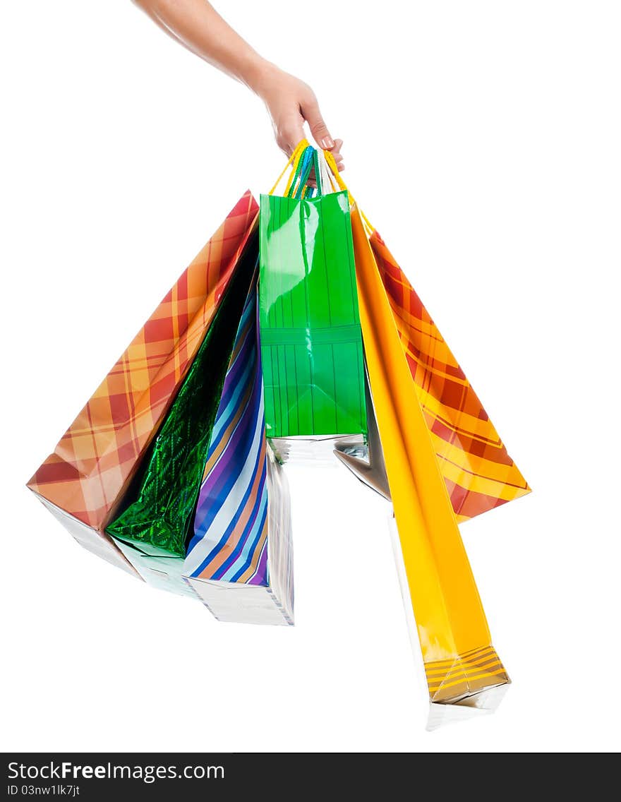 Female hand holding colorful shopping bags on white. Female hand holding colorful shopping bags on white