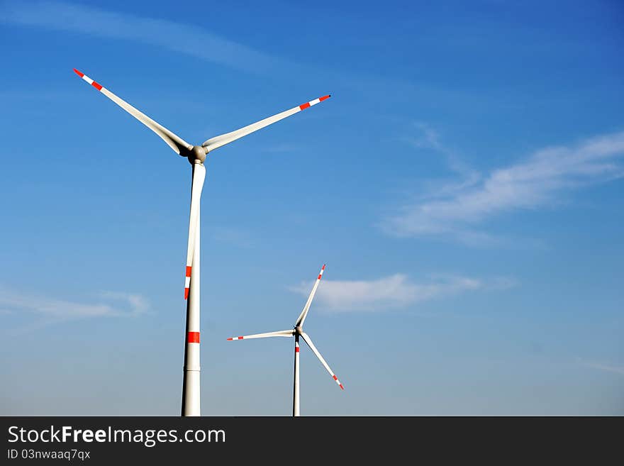 Wind turbine generating electricity on blue sky