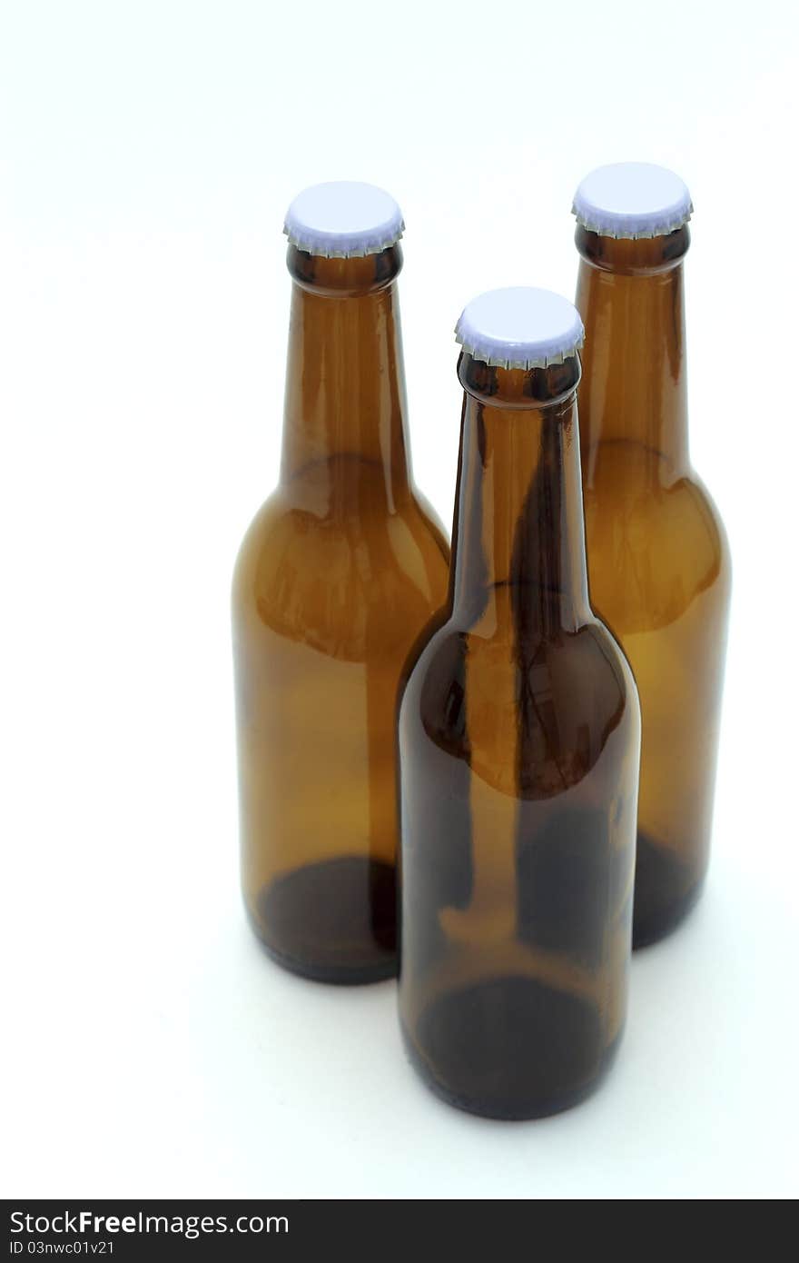 Three empty bottles of beer on white background