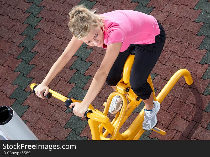 Young woman workout on stepper machine in a park. Young woman workout on stepper machine in a park