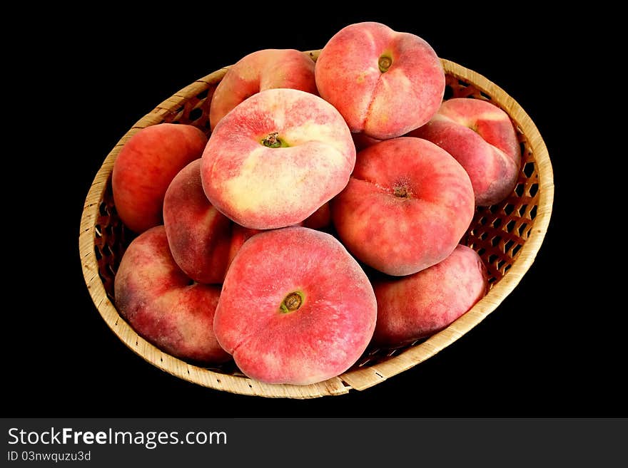 Mountain peach on wicker plate over black background. Mountain peach on wicker plate over black background