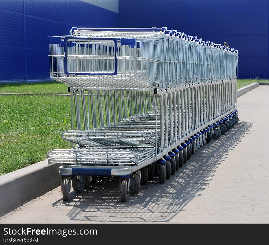 Row of white shopping carts in front of a shopping center