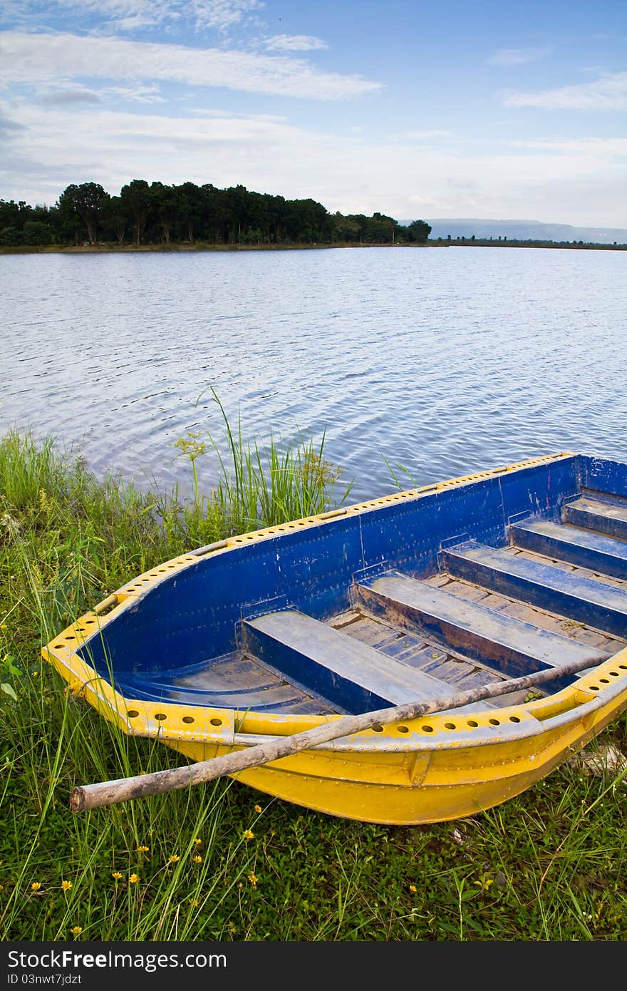 Yellow boat on the bank of the lake