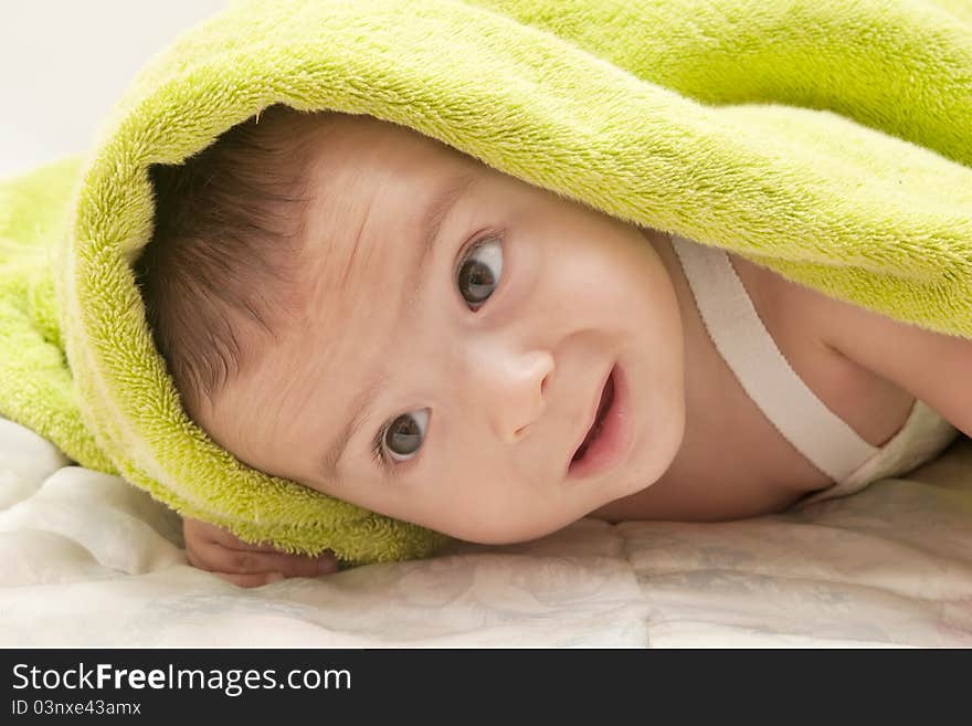 Beautiful baby with the green towel on white background. Beautiful baby with the green towel on white background