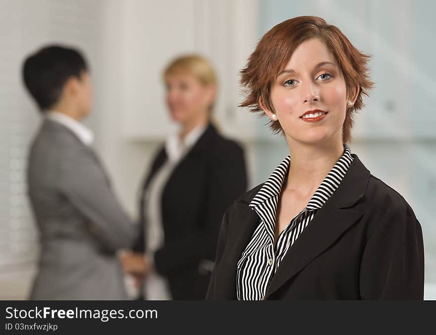 Pretty Businesswoman with Colleagues Behind