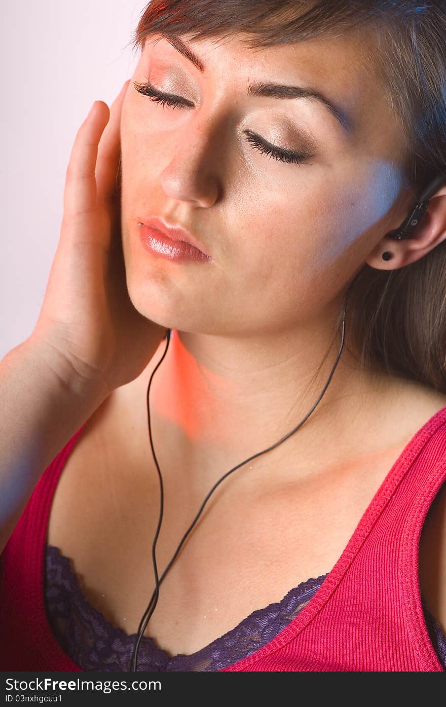 Teen woman listening to music on white with long dark hair and tank top