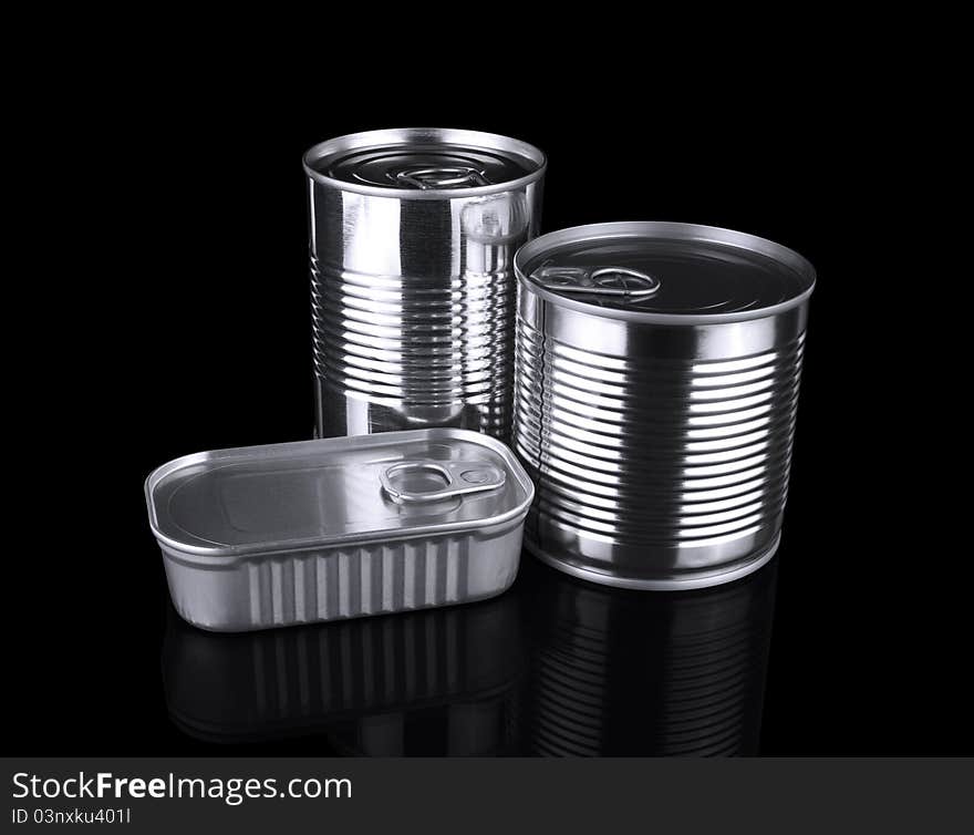 Three different unopened tin cans isolated on black.