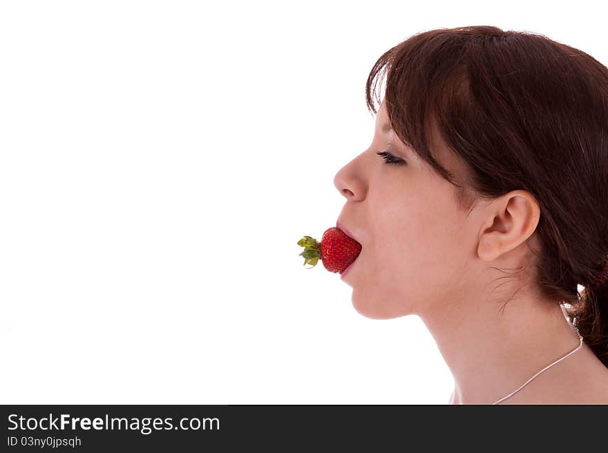 The pretty young woman has a strawberry in her mouth. The pretty young woman has a strawberry in her mouth