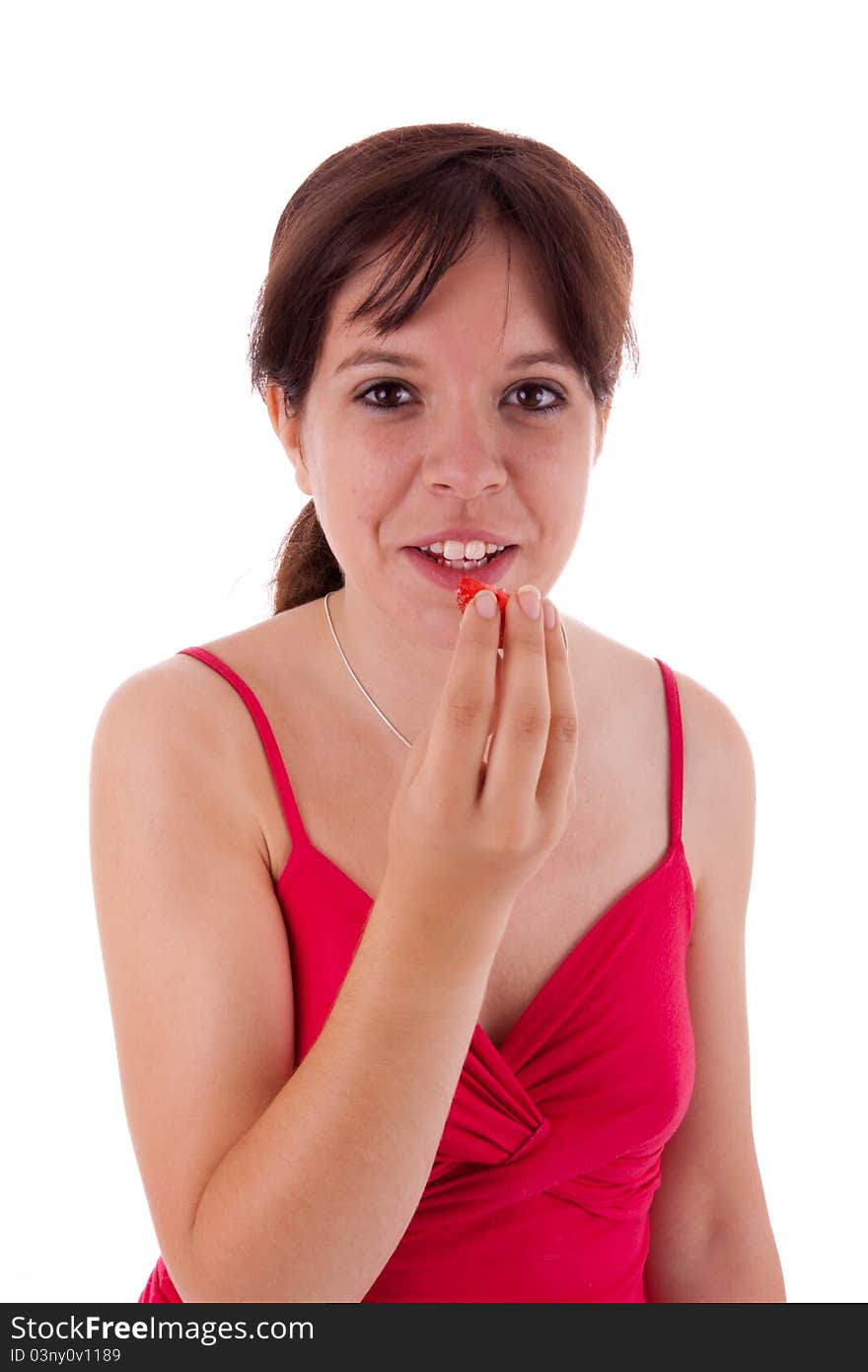 The pretty young woman eating a large strawberry. The pretty young woman eating a large strawberry