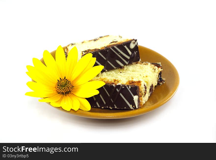 Sliced cake decorated with yellow flower on white background. Sliced cake decorated with yellow flower on white background