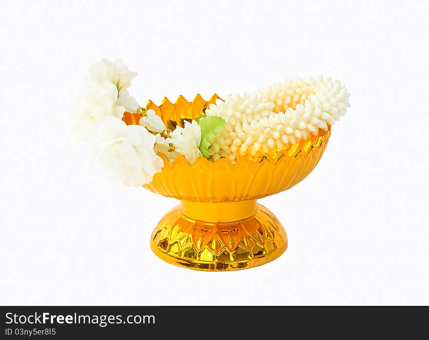 Jasmine garland on gold tray with pedestal, white background.