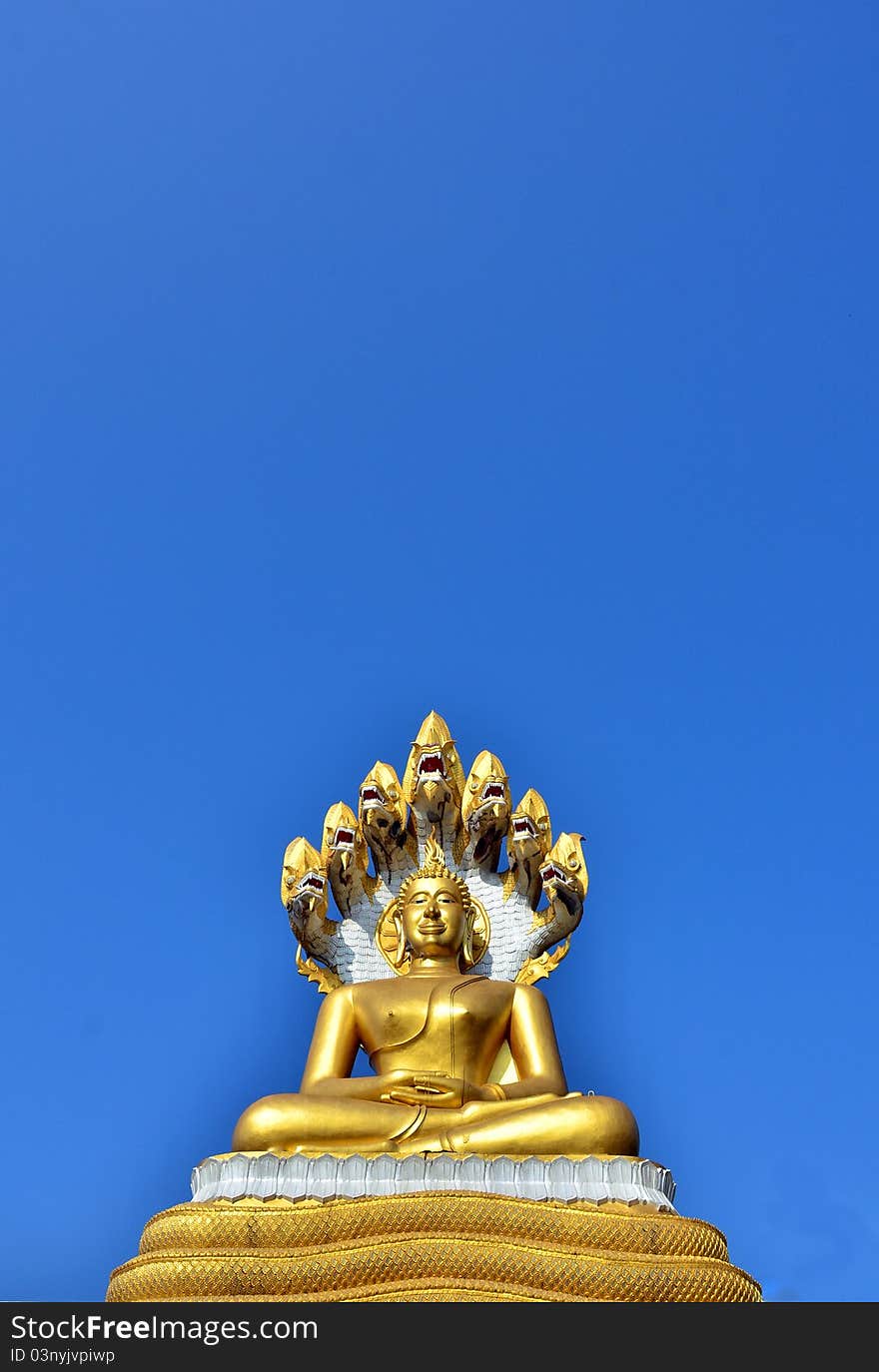 Gold Buddha statue over blue sky